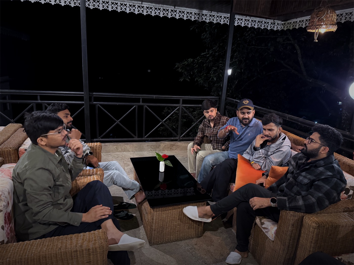 Team members deep in discussion on a hillside terrace at night