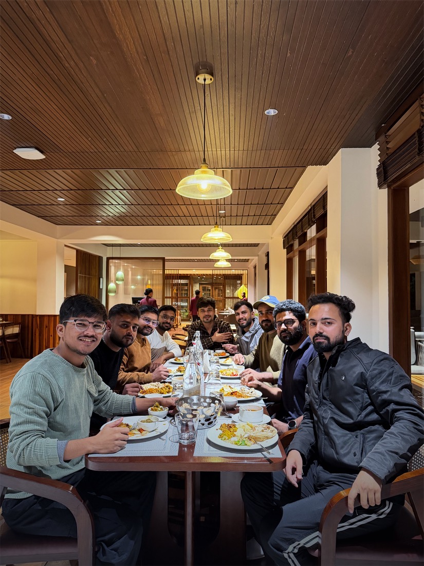 The team smiling around a long dinner table